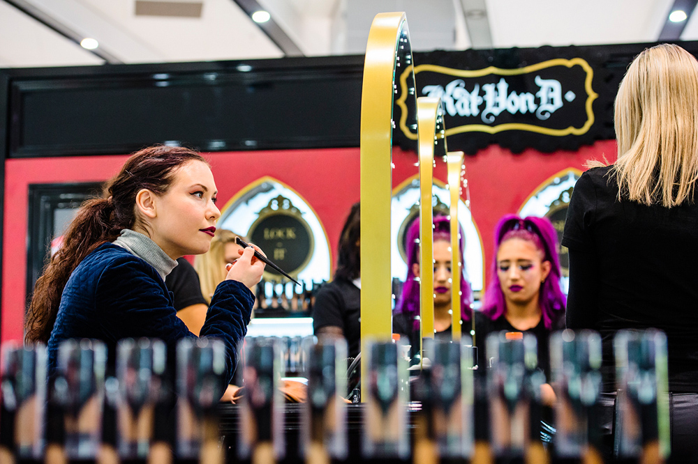 Customer applying make up at Kat Von D make up counter